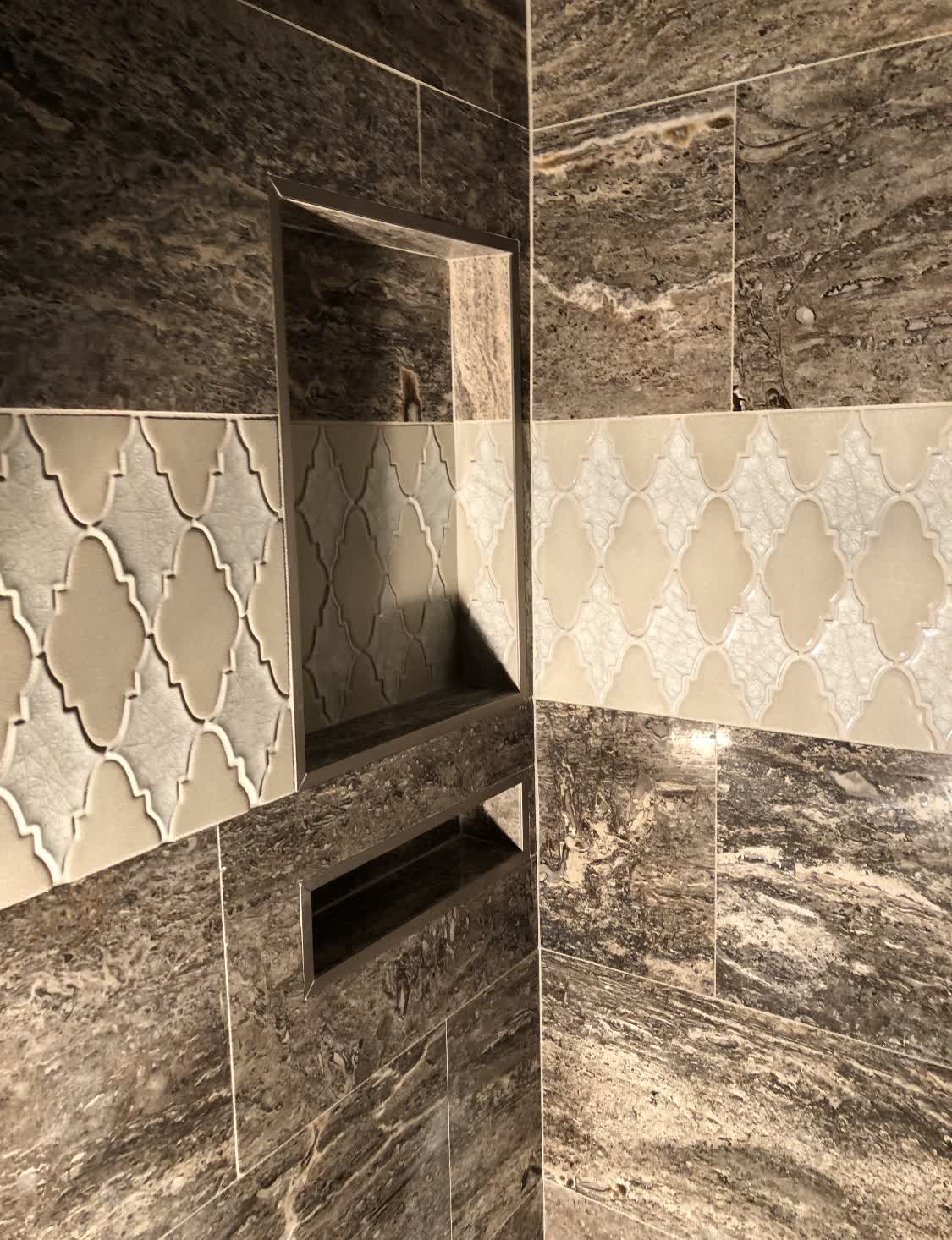 Dark stone shower with arabesque tile inlay