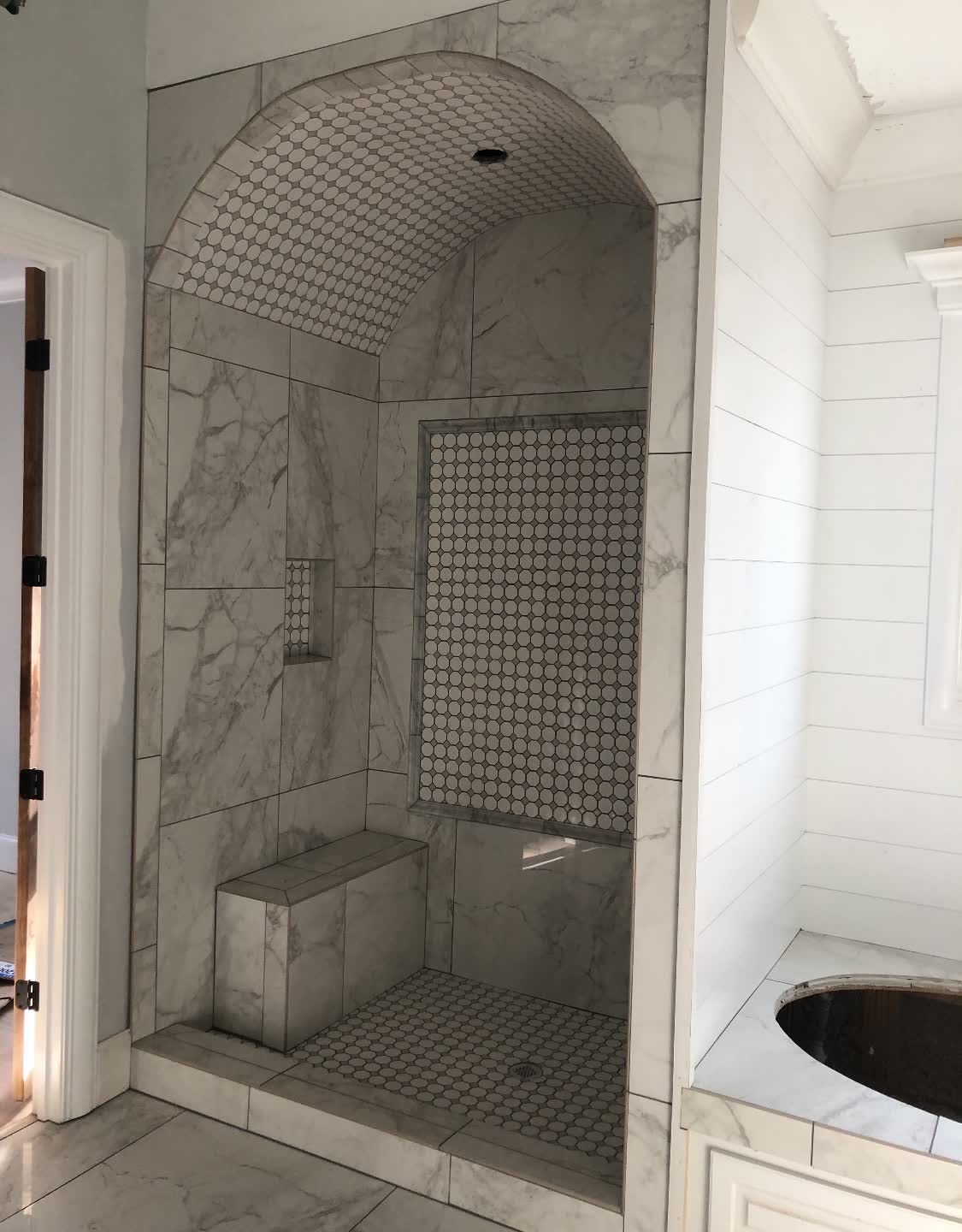 Custom marble shower with arched ceiling — bathroom remodel