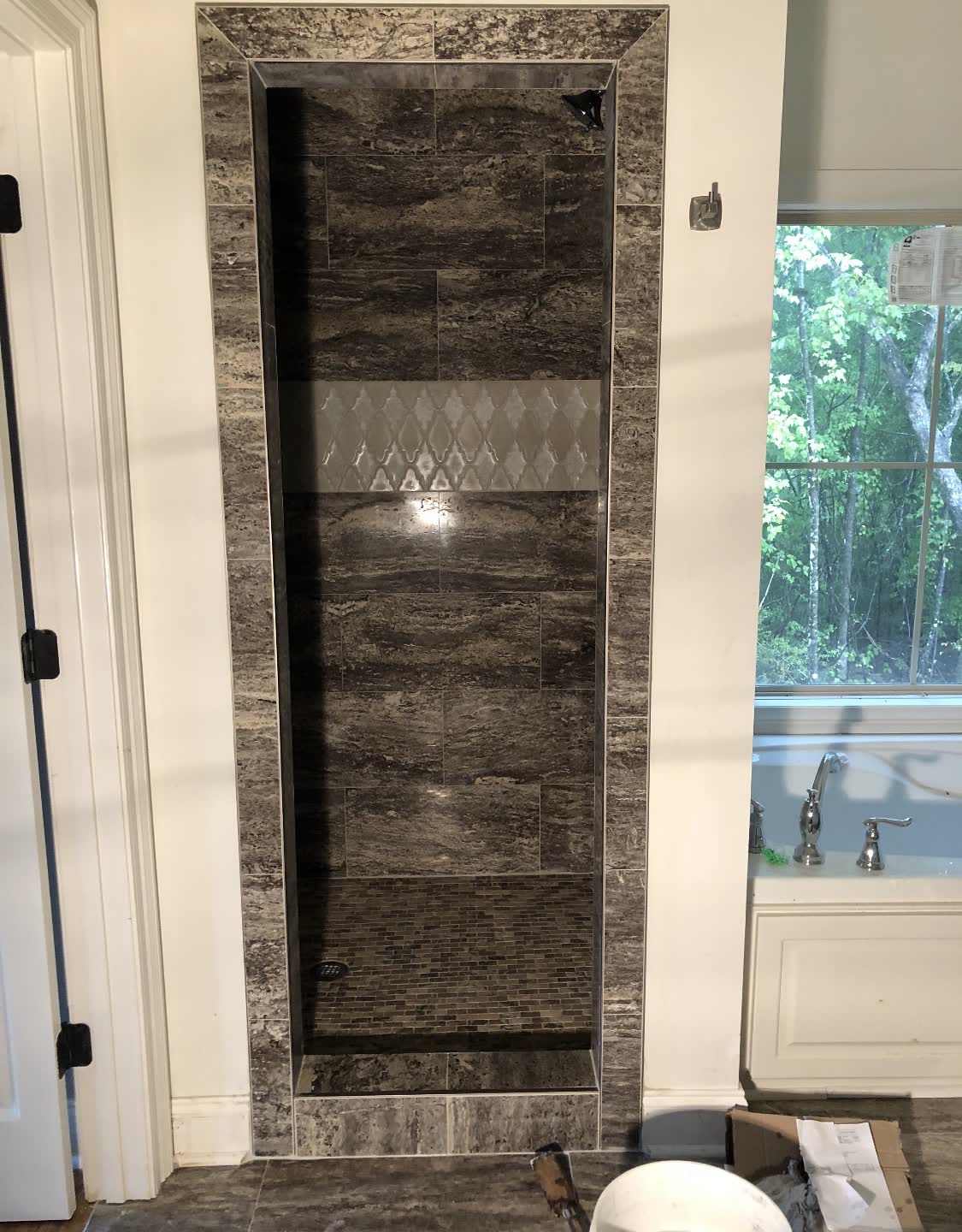Dark stone shower interior with full tile surround
