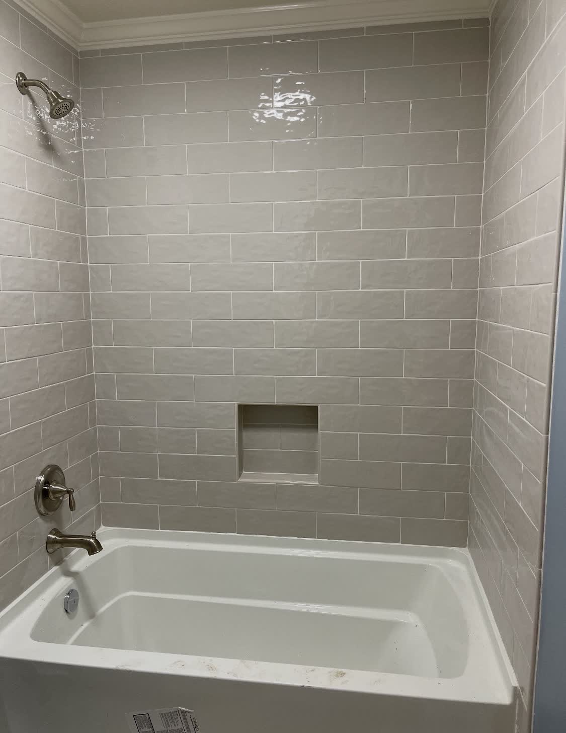 Soft-gray subway tile tub surround with niche