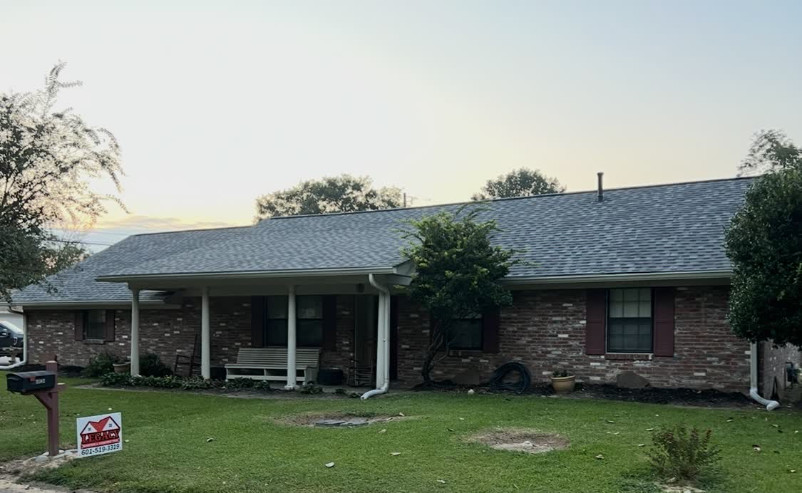 Brick rancher with finished roof at sunset, Legacy yard sign in foreground