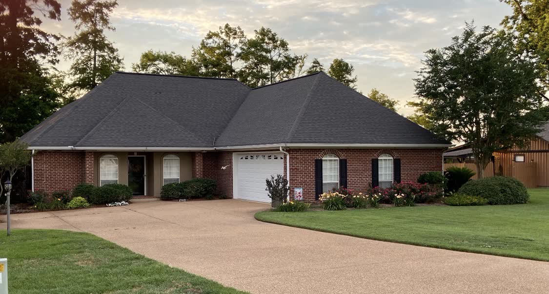 Brick home with new architectural shingle roof at golden hour