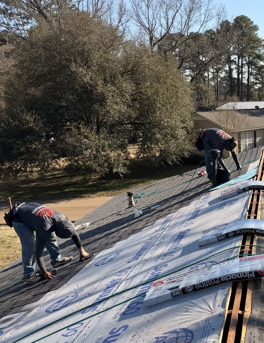 Crew laying underlayment on a steep pitch