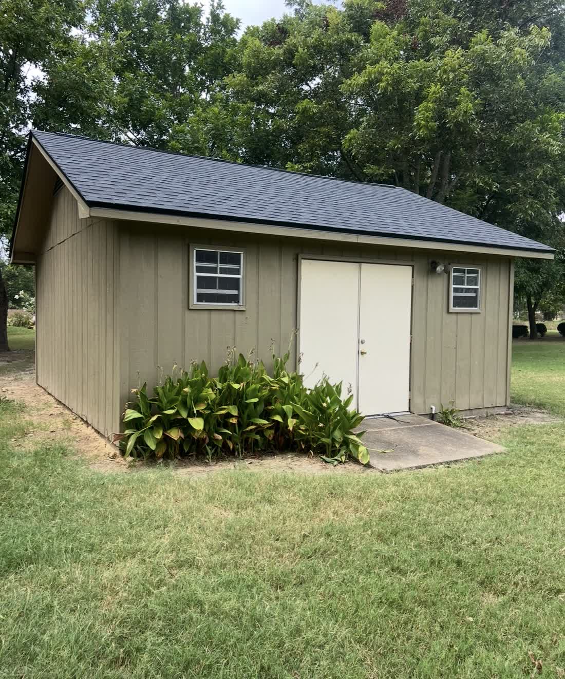 Custom storage shed with newly installed shingle roof