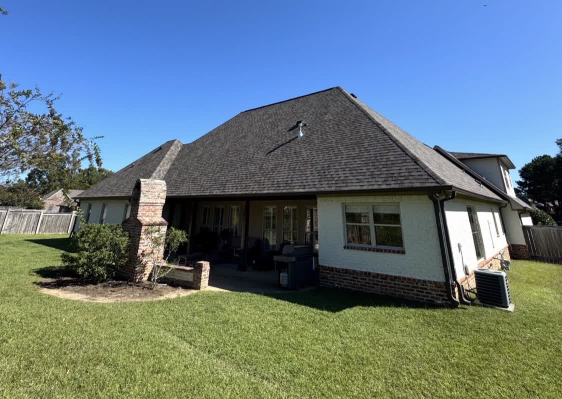 White brick Mississippi home with a freshly installed dark architectural shingle roof