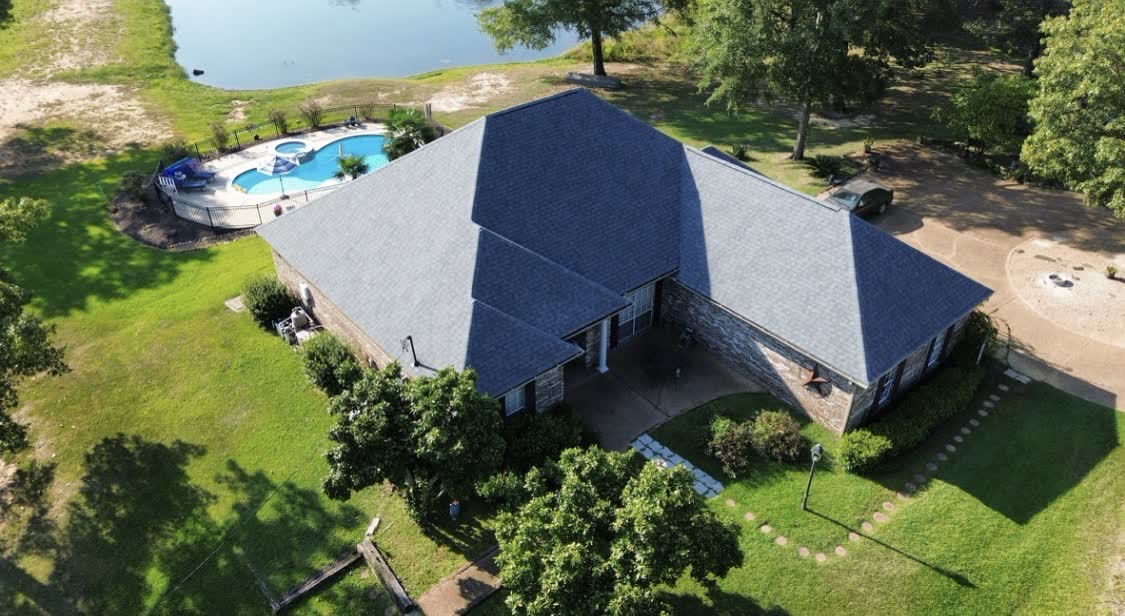Drone view of pool home with new shingle roof